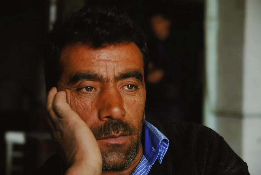 Man resting his head on his hand, lost in thought