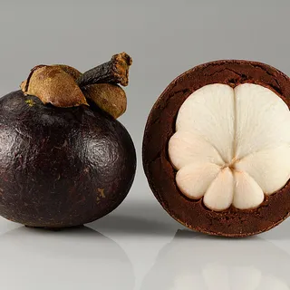 Whole and opened mangosteen fruit showing white segments